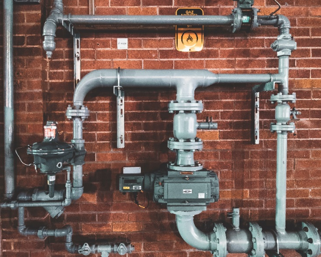Installation de tuyauterie de chauffage sur mur en briques